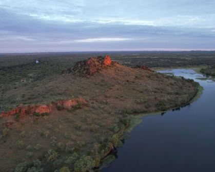 Picture of Chinamen CK Dam in Cloncurry. Sunsetting on the rocks overlooking the vast valley of dirt, trees, and the dam below.